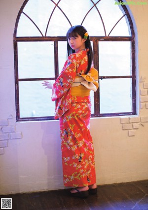 A woman in a red kimono with a flower in her hair.