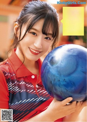 A couple of women standing next to each other holding bowling balls.