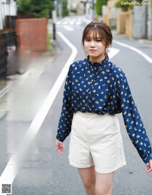 A woman standing in the middle of a street.