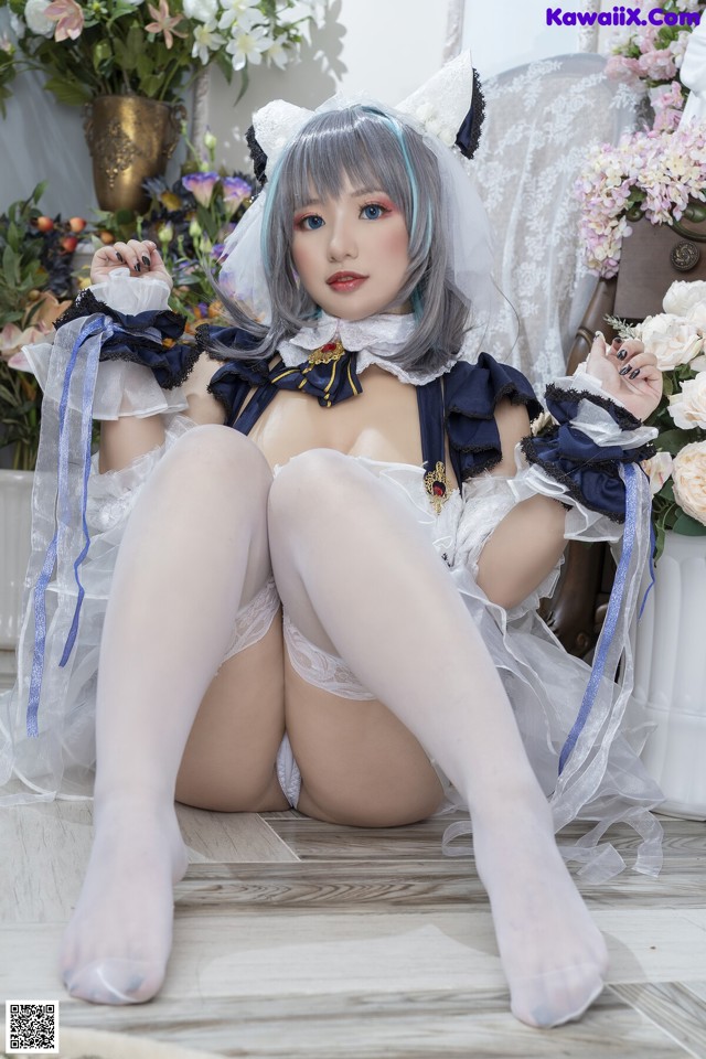 A woman in a maid outfit is sitting on the floor.