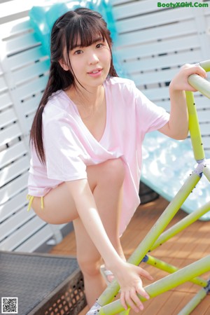 A young woman in a pink shirt is posing for a picture.