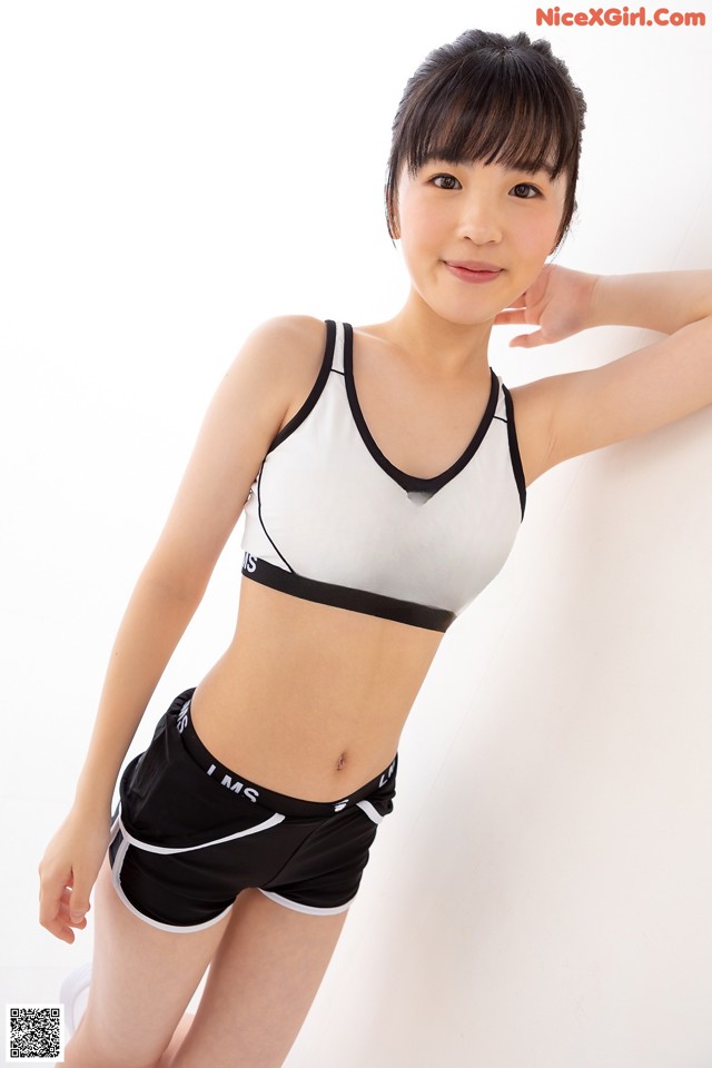A woman in a black and white sports bra top and shorts.