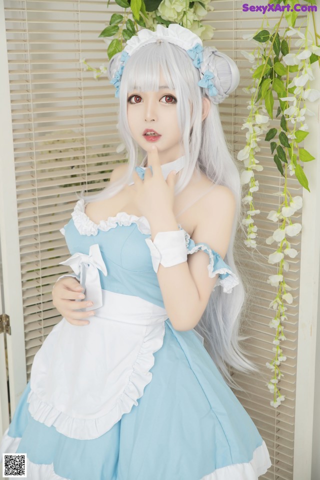 A woman in a blue and white dress posing for a picture.