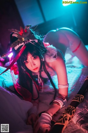 A woman in a red and white outfit is posing on a bed.