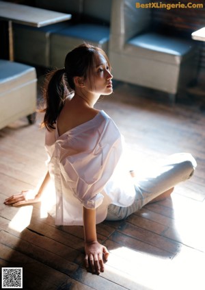 A woman sitting on a bench with her legs crossed.