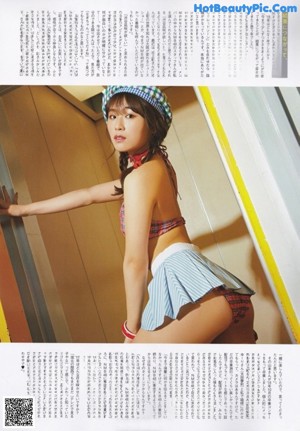 A woman in a plaid top and skirt posing for a magazine.