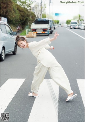 A young woman in a white shirt and pink skirt posing for a picture.