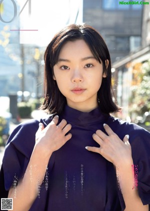 A woman with long black hair wearing a white sweater.